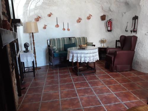 een woonkamer met een bank en een tafel bij Casa Rural Cueva El Sauce in Pegalajar