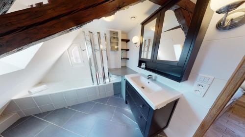 La salle de bains mansardée est pourvue d'un lavabo et d'un miroir. dans l'établissement Spacious duplex city center Strasbourg, à Strasbourg