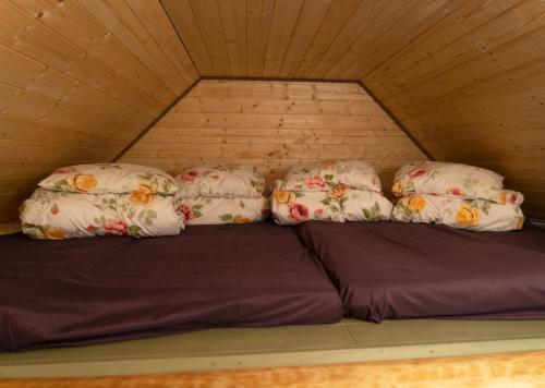 a bed with four pillows on top of it at Ansomäe Puhkeala Järvemaja in Otepää