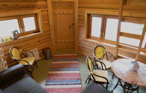 a room with a table and chairs in a cabin at Ansomäe Puhkeala Järvemaja in Otepää