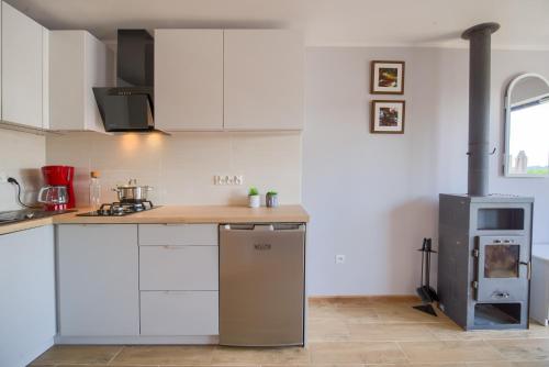 a kitchen with white cabinets and a counter top at Domki przy zalewie in Kamień Pomorski