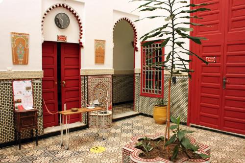 ein Zimmer mit roten Türen und einer Topfpflanze in der Unterkunft Riad Meftaha in Rabat