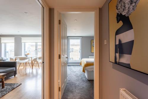 a hallway leading to a living room with a bedroom at Merchant City Modern 1 Bed Executive Flat in Glasgow