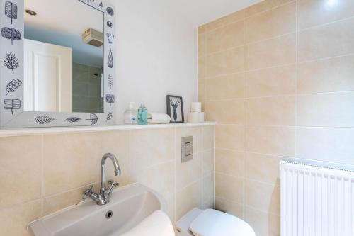 a bathroom with a sink and a toilet and a mirror at Merchant City Modern 1 Bed Executive Flat in Glasgow