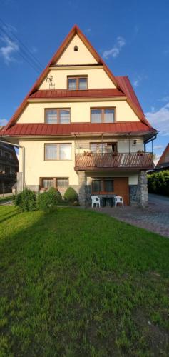 a large house with a large gambrel roof at Pokoje gościnne u Stocha in Poronin