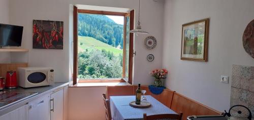 a kitchen with a table and a window at CASA IDA - ClPAT 22253 in Tregiovo