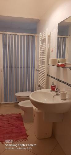 uma casa de banho com um lavatório branco e um WC. em Le cisterne Holiday Home em Manfredonia