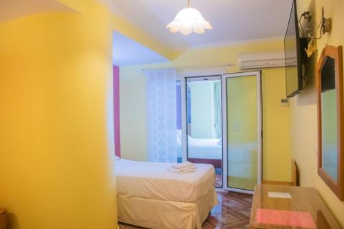 a small room with a bed and a mirror at Hotel Astoria in Igoumenitsa