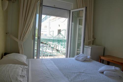 a bedroom with a bed and a sliding glass door at Hotel Astoria in Igoumenitsa