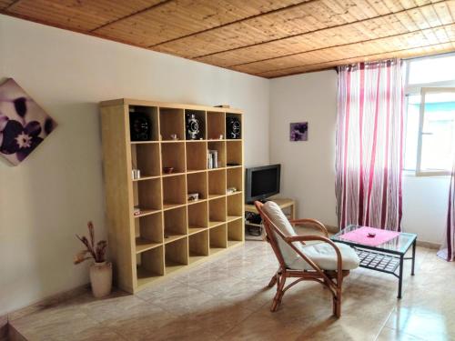 a living room with a book shelf and a table at Arguineguin, Ferienhaus direkt am Meer, Casa Perchel in Arguineguín