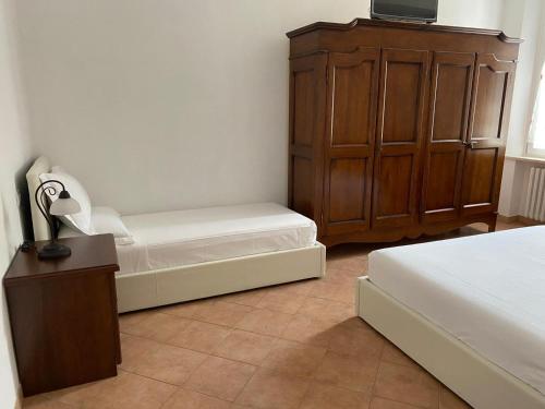 a bedroom with two beds and a dresser and a cabinet at B&B Giulia in Parma