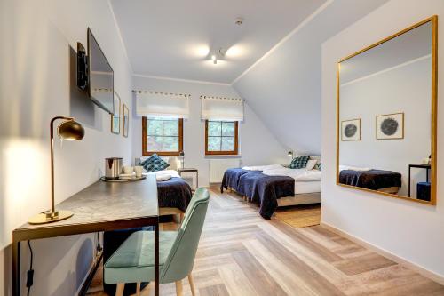 a bedroom with a bed and a desk and a mirror at POD DEBEM Kompleks Zeglarsko-Rekreacyjny in Ruciane-Nida