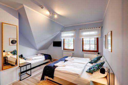 a bedroom with two beds and a mirror at POD DEBEM Kompleks Zeglarsko-Rekreacyjny in Ruciane-Nida