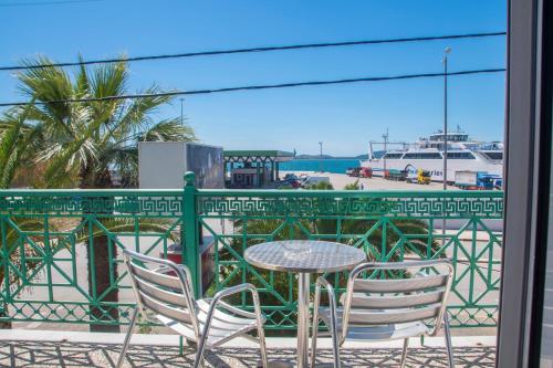 a table and chairs on a balcony with a view of a harbor at Hotel Astoria in Igoumenitsa