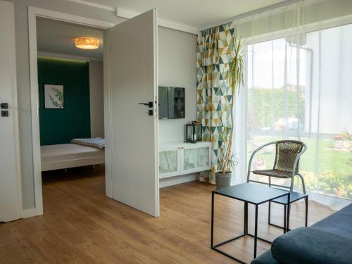 Różany Domek في غروجونتس: غرفة معيشة بها أريكة وكرسي ونافذة