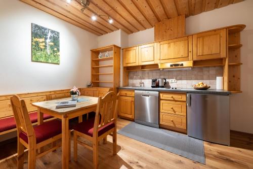a kitchen with wooden cabinets and a table and chairs at Biochalet Märkl in Bad Kleinkirchheim