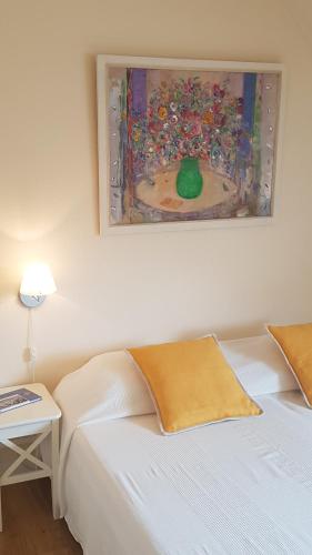 a white bed in a room with a painting on the wall at Bed & Breakfast de Echo in Muiderberg