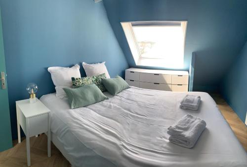 - une chambre bleue avec un grand lit et des serviettes dans l'établissement LE BELLE VUE, à Wissant