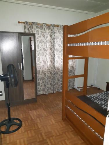 a bedroom with a bunk bed and a mirror at Zya 3BR A-House in Baguio