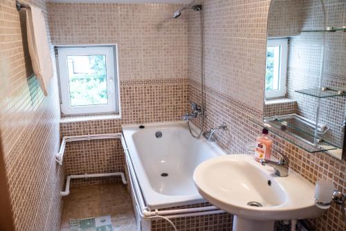 a bathroom with a bath tub and a sink at Vila Diamant in Neptun