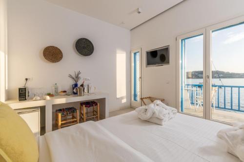 Biała sypialnia z dużym łóżkiem i widokiem na ocean w obiekcie Bluetopia Suites w mieście Mykonos