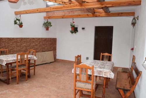 a dining room with wooden tables and chairs and a room with a door at Casa Visescu in Băile Herculane