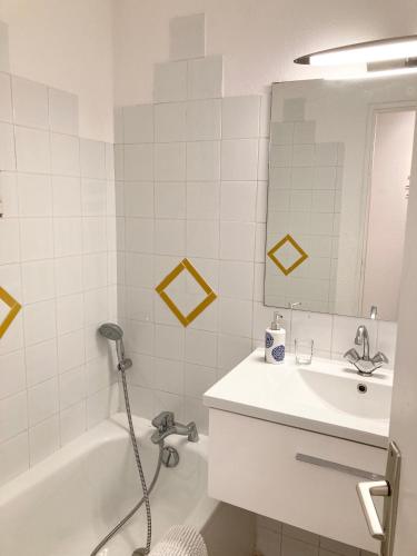 une salle de bain avec un lavabo, une baignoire et un miroir dans l'établissement l'escale, à Cogolin