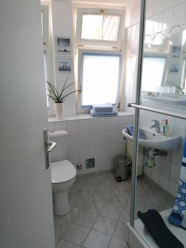 a bathroom with a toilet and a sink and a window at Maisonette "im Alten Pfarrhaus" in Neuruppin