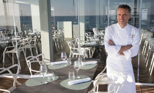 a chef standing in front of a table with wine glasses at Luna Minoica Suites and Apartments in Montallegro
