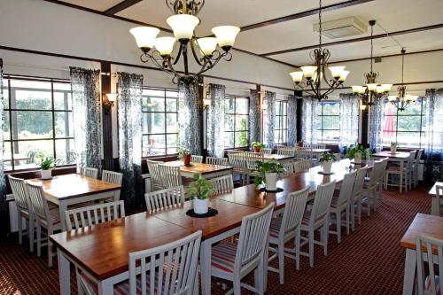 - une salle à manger avec des tables, des chaises et des fenêtres dans l'établissement Rasta Hallandsåsen, à Båstad