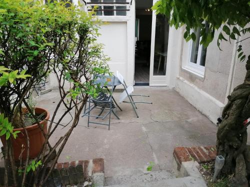 a patio with a table and chairs in front of a door at Petit studio hypercentre d'Orléans avec jardin in Orléans