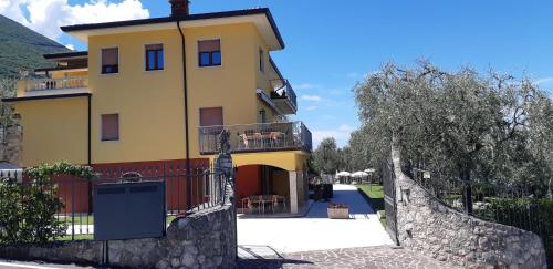 a yellow house with a balcony and a fence at Villa Due Leoni - Residence in Brenzone sul Garda