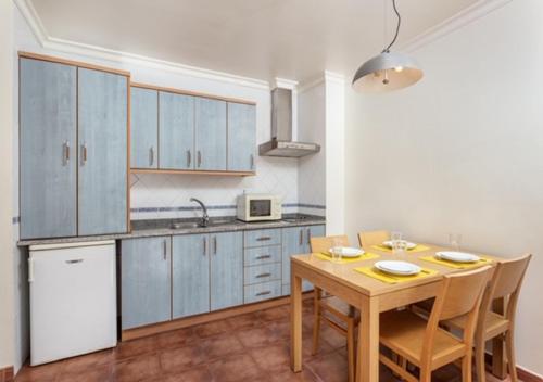 a kitchen with a wooden table and a table and chairs at Altura Beach AL2 in Altura