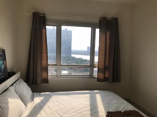a bedroom with a bed and a large window at river front in Nonthaburi
