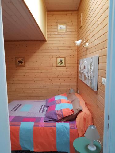 - une chambre avec un lit dans une pièce en bois dans l'établissement Gîte Mercues, à Mercuès