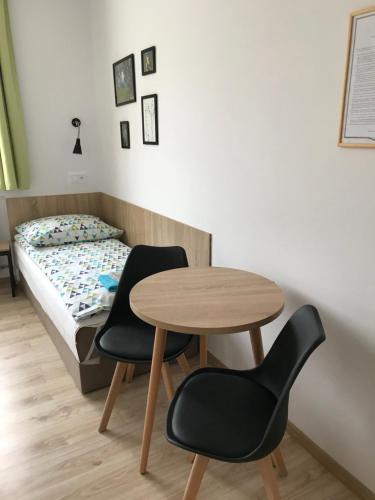a room with a table and two chairs and a bed at Kathia Pokoje Gościnne in Katowice