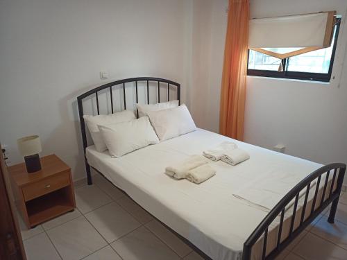 a bedroom with a bed with two towels on it at Marietta's Apartments in Agios Andreas