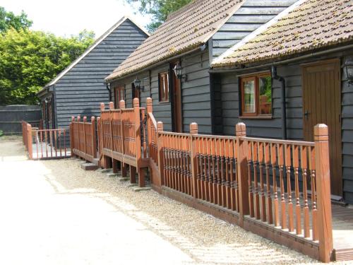 a wooden fence in front of a house at Warmans Barn in Stansted Mountfitchet