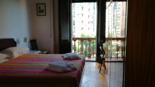 a bedroom with a bed and a window with a balcony at Hotel Gambara in Milan