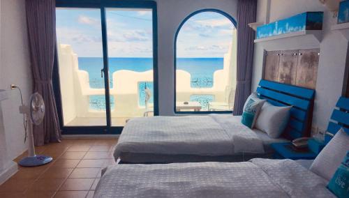 a bedroom with two beds and a view of the ocean at Seyan Inn in Eluan