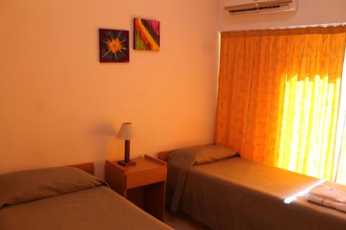 a small room with two beds and a window at Bet Hotel Buenos Aires in Buenos Aires