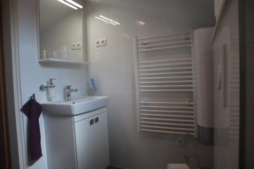 a white bathroom with a sink and a shower at Apartments Iva und Franka in Omiš