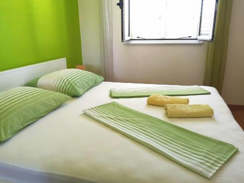 two beds with green and white sheets and pillows at Apartment Vucic in Makarska