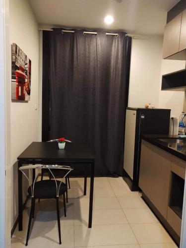 a kitchen with a black table and a black refrigerator at the base in Udon Thani