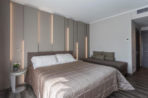 a bedroom with a large bed and a couch at Hotel Giulietta Romeo in Lazise