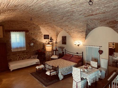 a living room with a bed and a brick wall at LA GUARDIOLA DEL TEMPIO in Perugia
