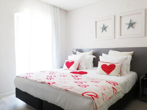 
a bed with a white bedspread and pillows at Hotel Mar Bravo in Nazaré
