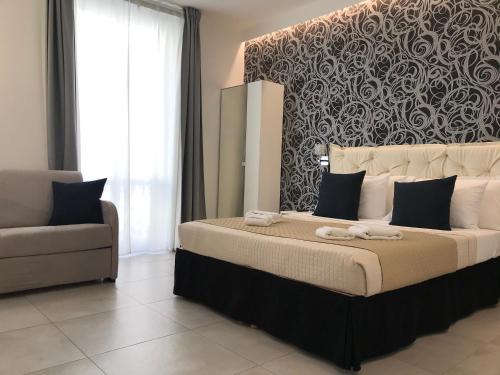 ein Schlafzimmer mit einem großen Bett und einem Stuhl in der Unterkunft Alba rooms in La Spezia