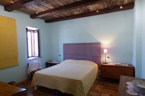 Schlafzimmer mit einem Bett, einem Tisch und einem Fenster in der Unterkunft Il Nibbio - Il Rifugio del Viandante in Morano Calabro