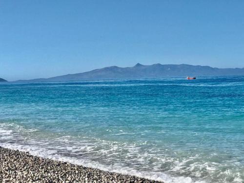 a boat in the water on a beach at Violet Village in Borsh